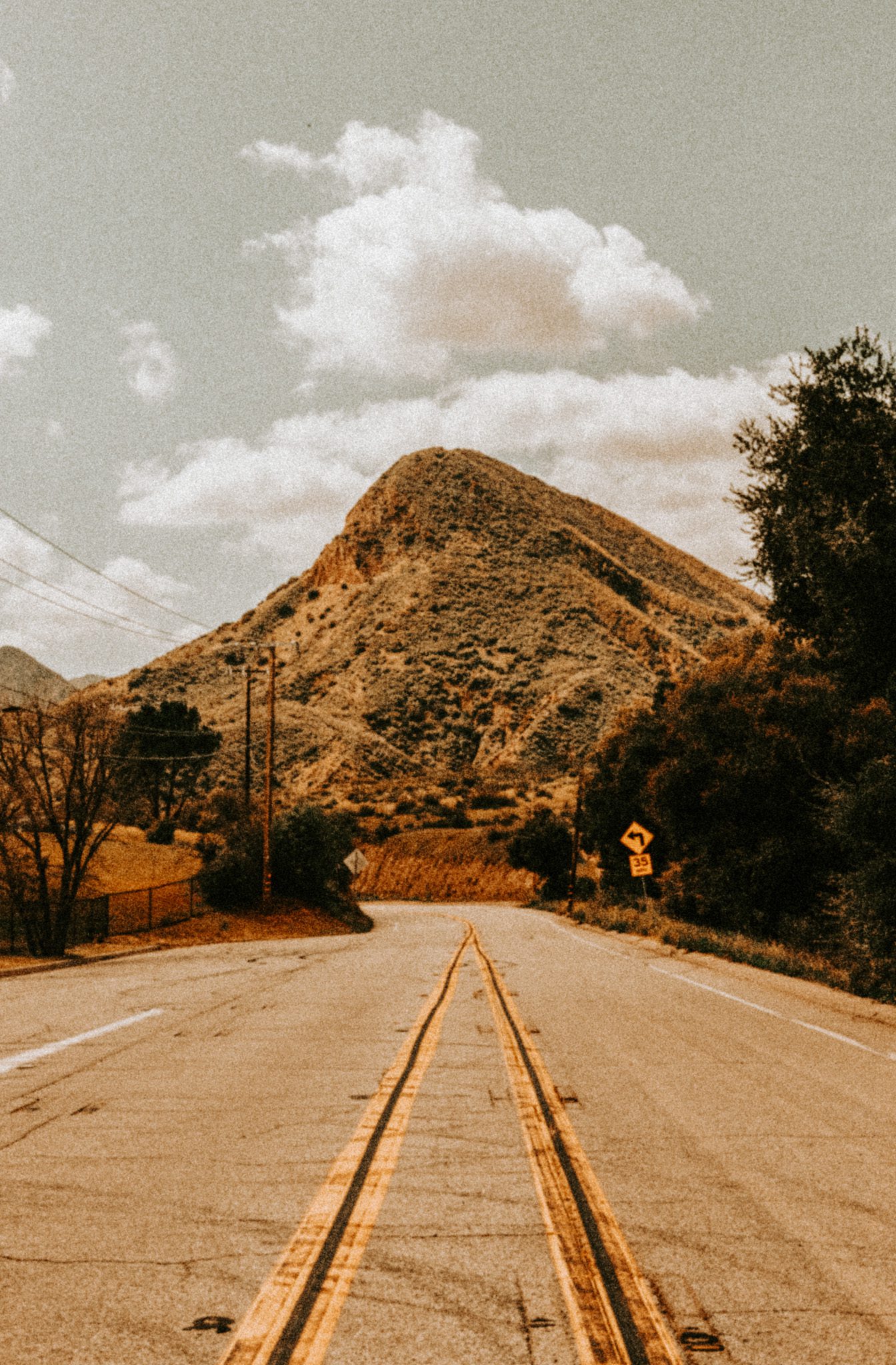 Empty road on hill under white sky